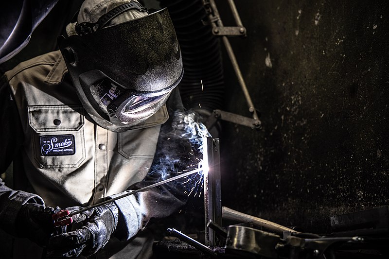 Skilled industrial welder working on metal fabrication.